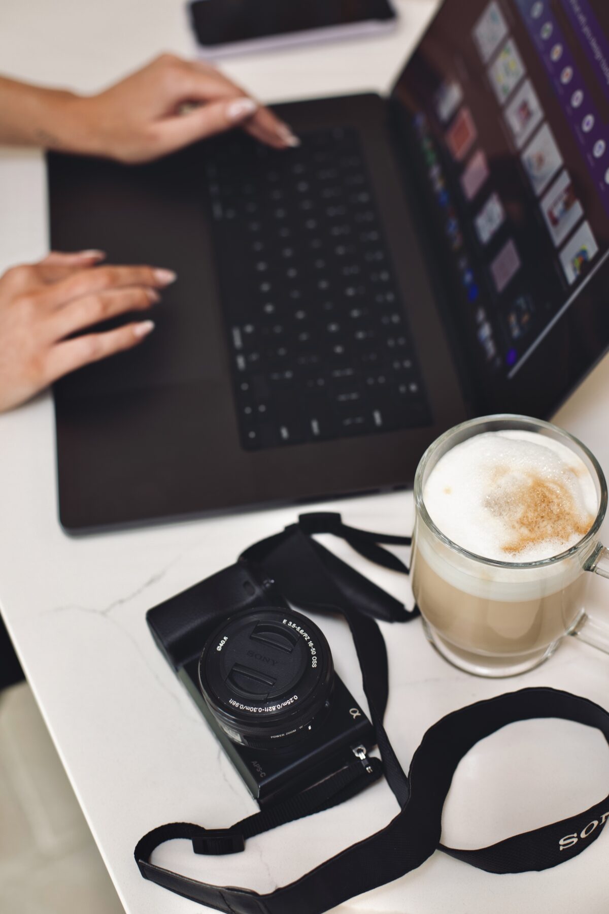 Laptop, camera and coffee on Kayce Sadler's desk at Abode Marketing