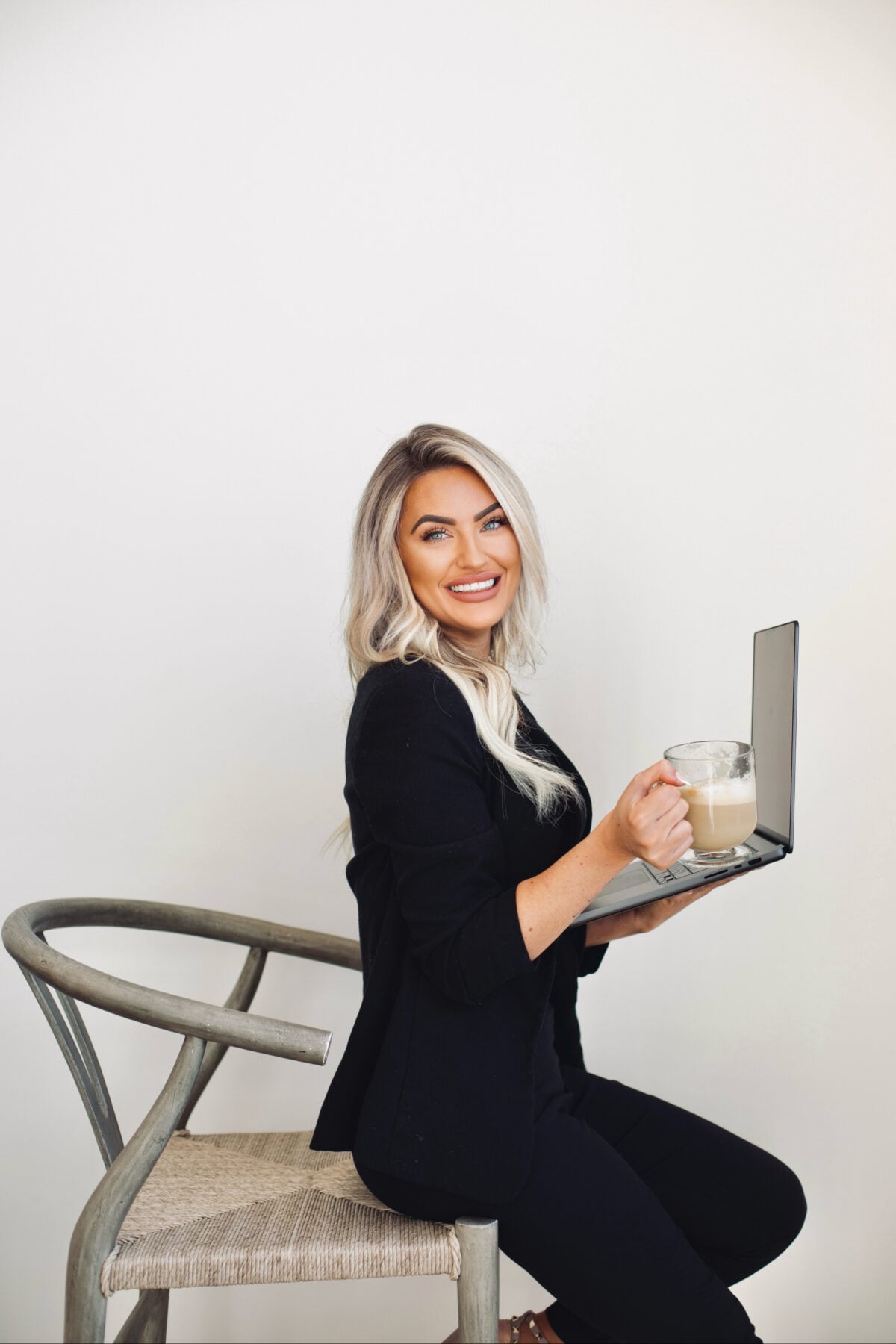 Kayce Sadler, founder of Abode Marketing, working on her laptop