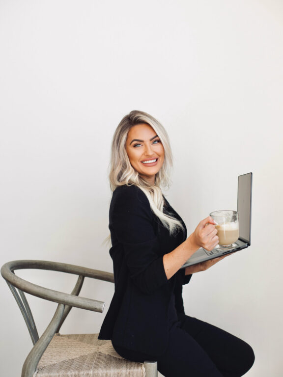 Kayce Sadler, founder of Abode Marketing, working on her laptop