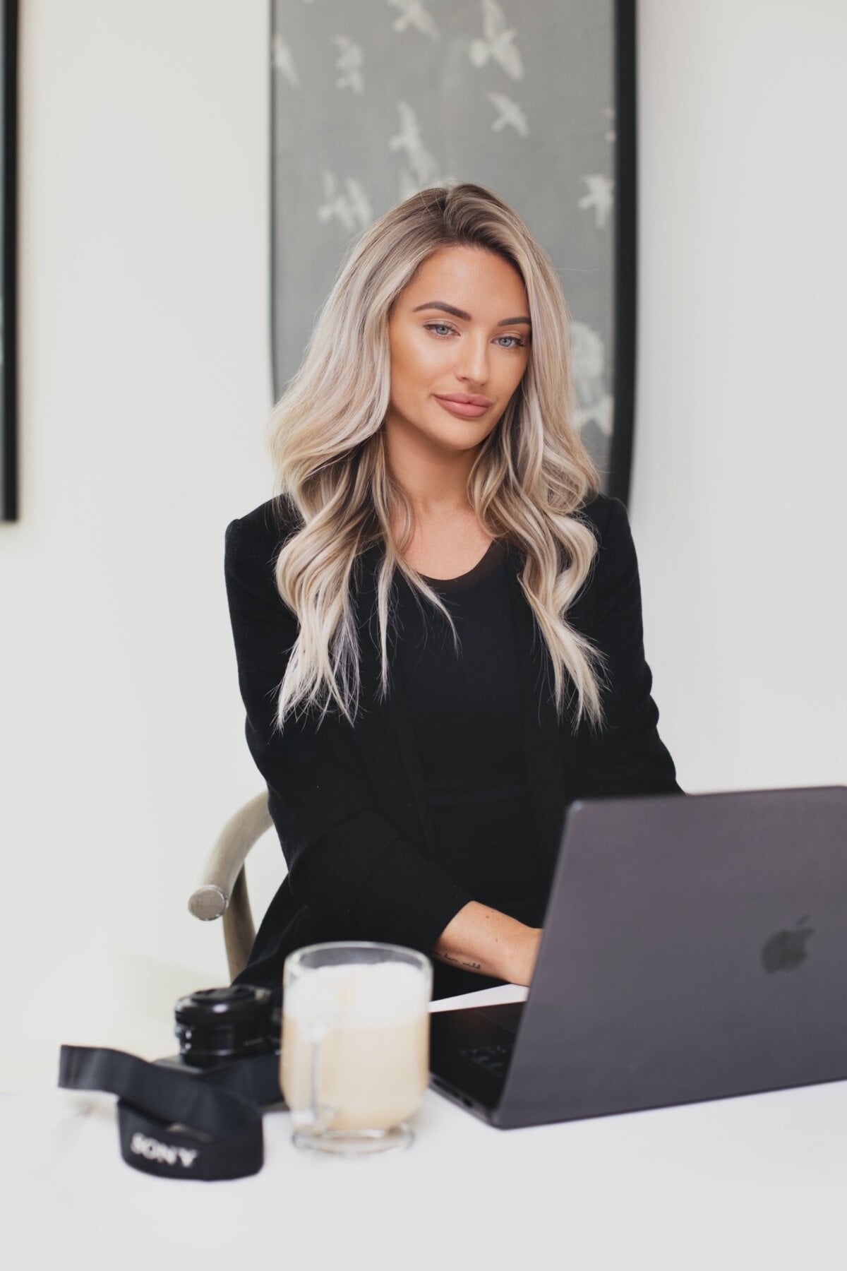 Kayce Sadler, founder of Abode Marketing, working at her laptop